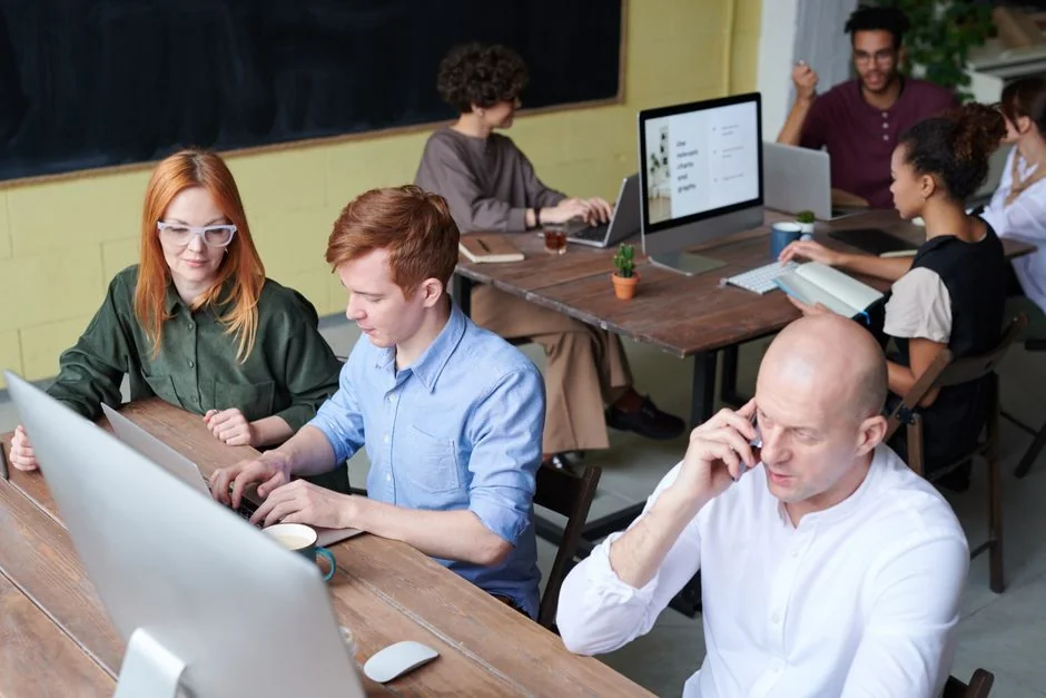 Adulte travaillant sur un ordinateur portable dans un bureau moderne, illustrant la productivité et la concentration.